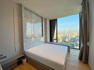 Modern bedroom with large windows and city view