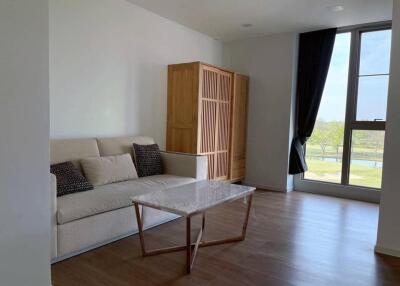 Living room with a sofa, coffee table, and large window