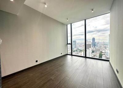 Spacious empty room with large floor-to-ceiling windows and city view
