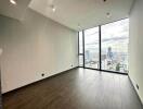 Spacious empty room with large floor-to-ceiling windows and city view