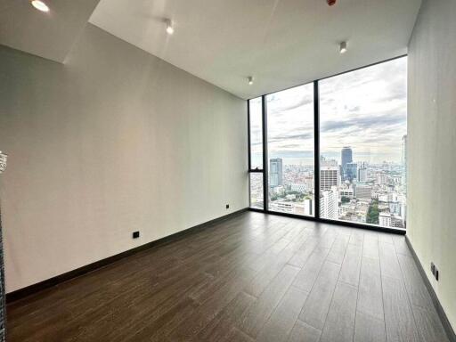 Spacious empty room with large floor-to-ceiling windows and city view