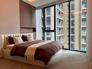 Modern bedroom with large windows and view of neighboring buildings