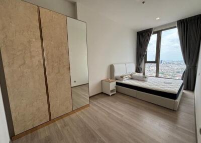 Modern bedroom with a large window, bed, and wardrobe