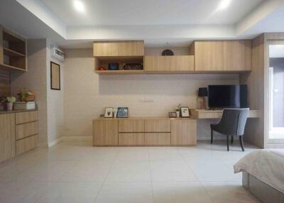 Modern minimalist living space with built-in wooden cabinetry and office desk