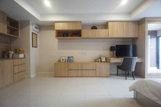 Modern minimalist living space with built-in wooden cabinetry and office desk