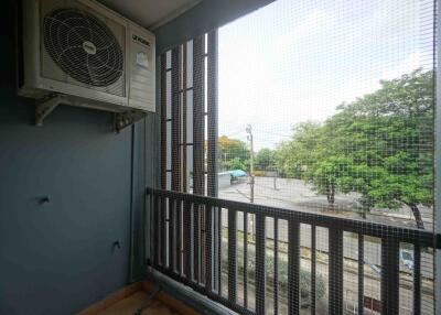 Balcony with air conditioning unit and view of trees and street