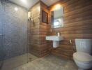 Modern bathroom with wooden paneling and tiled shower area