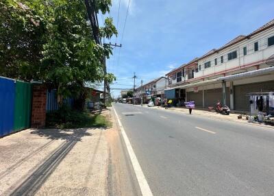 Street view of neighborhood with buildings, shops, and street vendors