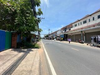 Street view of neighborhood with buildings, shops, and street vendors