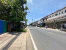 Street view of neighborhood with buildings, shops, and street vendors