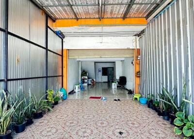 Covered outdoor area with plants and tiled floor