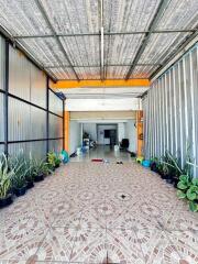 Covered outdoor area with plants and tiled floor