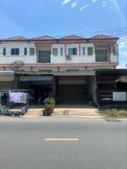 Front view of a commercial building with shops and residential space