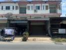 Front view of a commercial building with shops and residential space