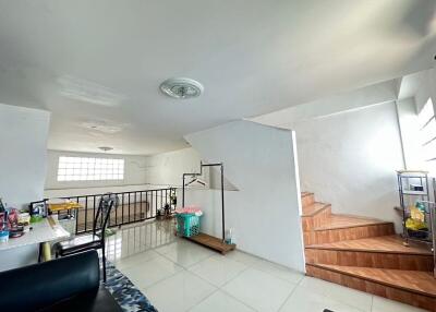 spacious well-lit living area with stairs and interior decor