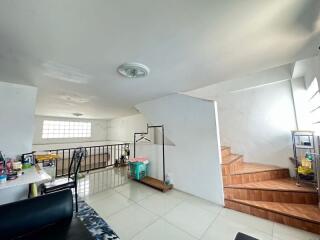 spacious well-lit living area with stairs and interior decor