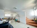 spacious well-lit living area with stairs and interior decor