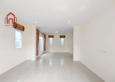 Spacious empty living room with large windows and recessed lighting