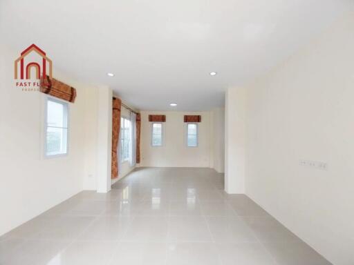 Spacious empty living room with large windows and recessed lighting