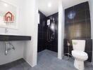 Modern bathroom with black tiles and shower area