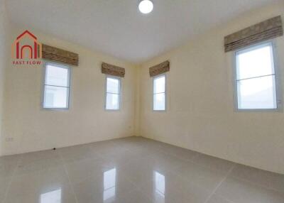 Spacious bedroom with tile flooring and multiple windows