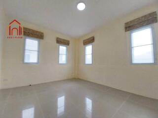 Spacious bedroom with tile flooring and multiple windows