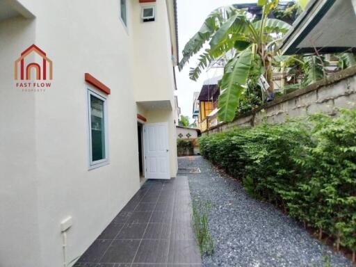 Image of a backyard space with greenery and a building