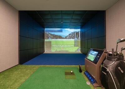 Indoor room featuring a golf simulator with screen projection and equipment