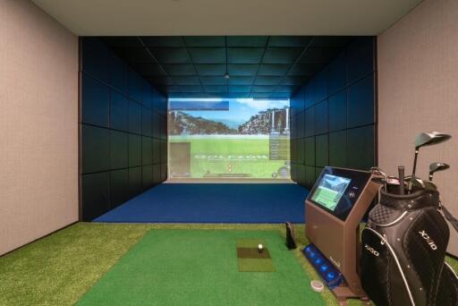 Indoor room featuring a golf simulator with screen projection and equipment