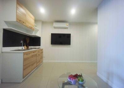 Modern kitchen area with wall-mounted TV