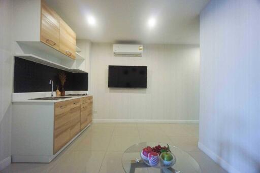 Modern kitchen area with wall-mounted TV