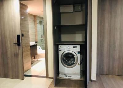 Laundry area with a washing machine and a view into the bathroom