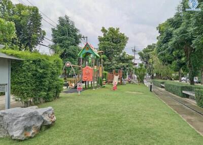 Outdoor playground in a green park area with various play equipment