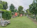 Outdoor playground in a green park area with various play equipment