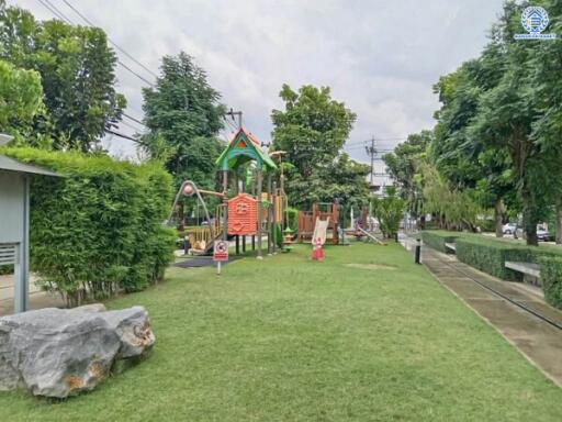 Outdoor playground in a green park area with various play equipment