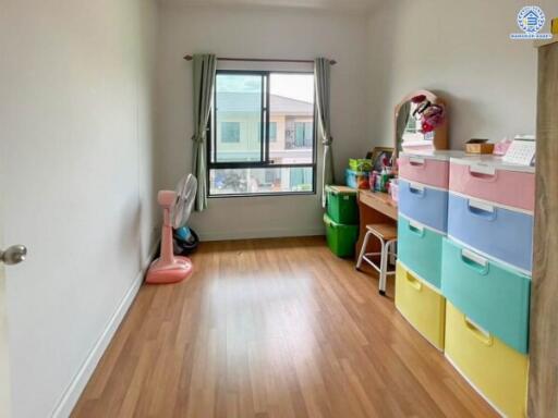 Bedroom with colorful storage drawers and desk near window