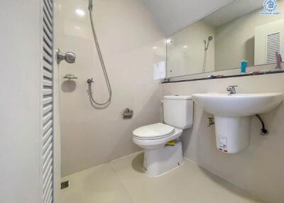 Modern bathroom with white fixtures, a toilet, sink, and shower