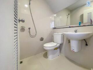 Modern bathroom with white fixtures, a toilet, sink, and shower