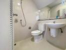 Modern bathroom with white fixtures, a toilet, sink, and shower