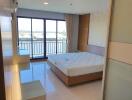 Bright bedroom with large windows and a balcony view