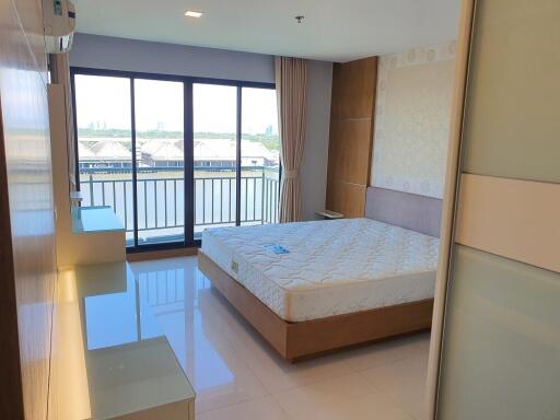 Bright bedroom with large windows and a balcony view