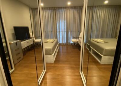 Modern bedroom with mirrored closet doors and wooden flooring