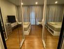 Modern bedroom with mirrored closet doors and wooden flooring