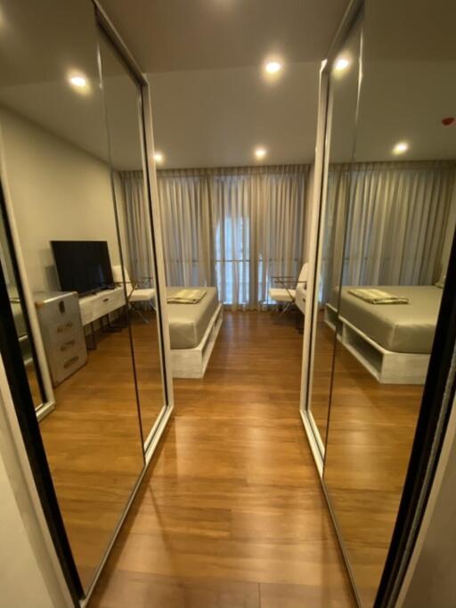 Modern bedroom with mirrored closet doors and wooden flooring