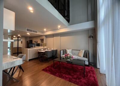 Modern living room with high ceiling, hardwood floor, and contemporary furniture