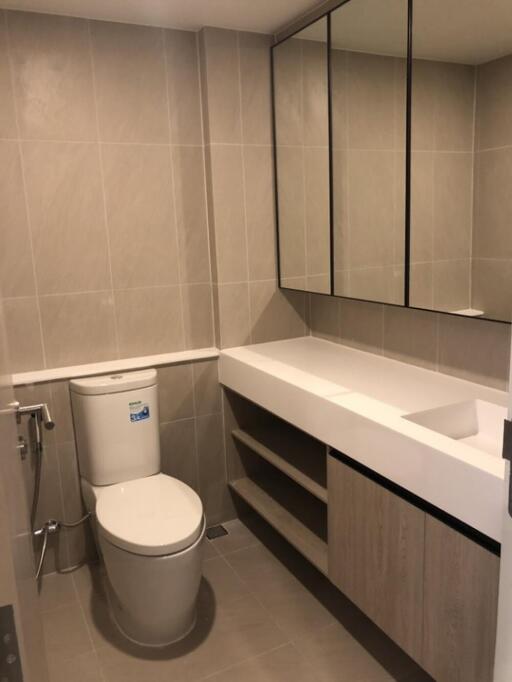 Modern bathroom with tiled walls and a large mirror