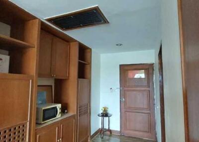 Hallway with wooden cabinets and door