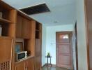 Hallway with wooden cabinets and door