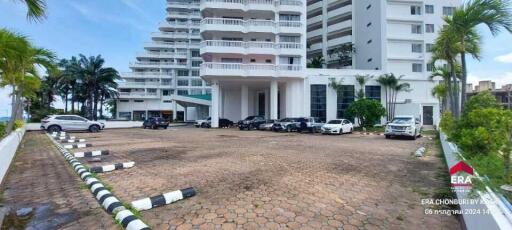 Exterior view of a modern residential building with parking area