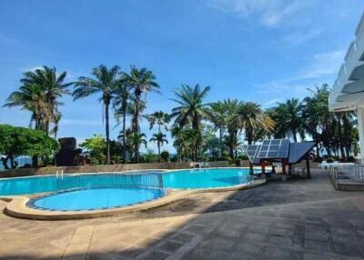 Outdoor pool area with seating and palm trees